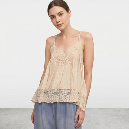 Woman in beige lace top with light blue jeans.