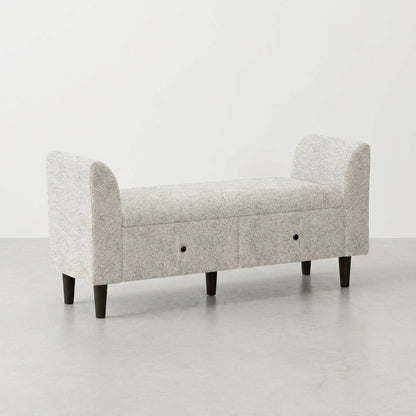 Gray storage bench with two open drawers and rounded armrests.