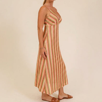 Woman in a colorful striped maxi dress and sandals.