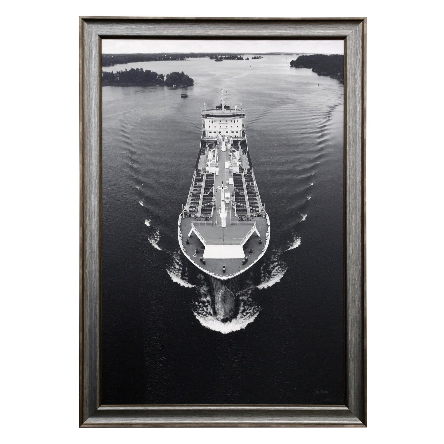 Black and white framed photo of a cargo ship on a calm waterway.