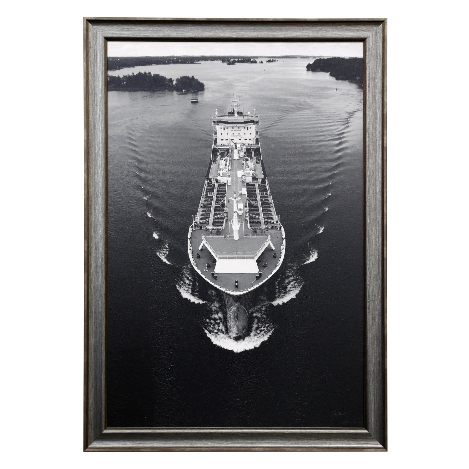 Black and white framed photo of a cargo ship on a calm waterway.