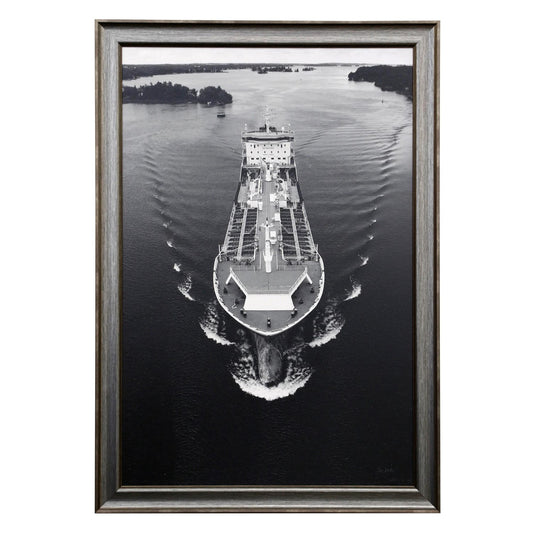Black and white framed photo of a cargo ship on a calm waterway.
