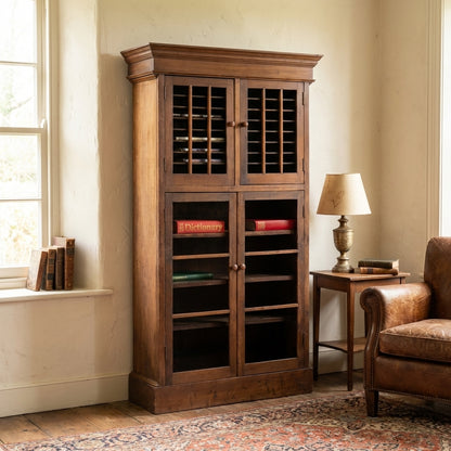Wooden cabinet with books, next to a lamp and leather chair.