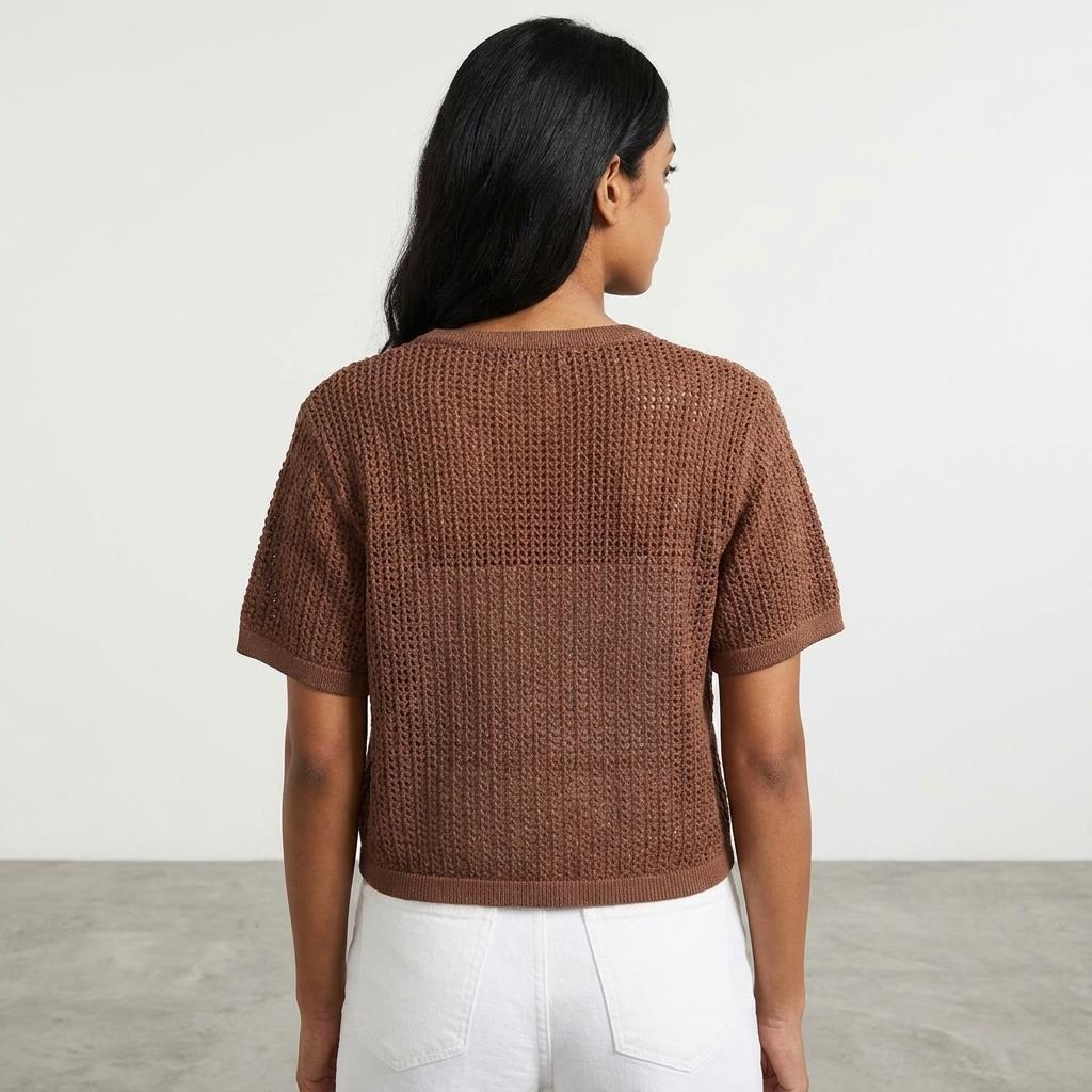Person in brown knit top and white pants, viewed from behind.
