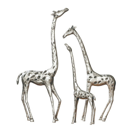 Three silver giraffe sculptures with long necks and spots.