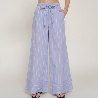 Blue striped wide-leg pants with a waist tie, worn with sandals.