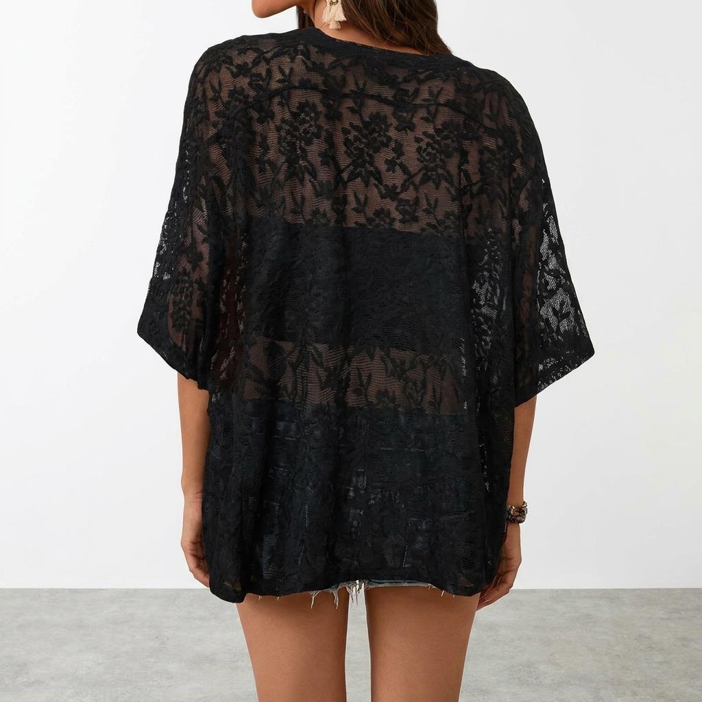 Person in black lace top and denim shorts, facing away.