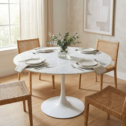 Round white pedestal table with a marble top.