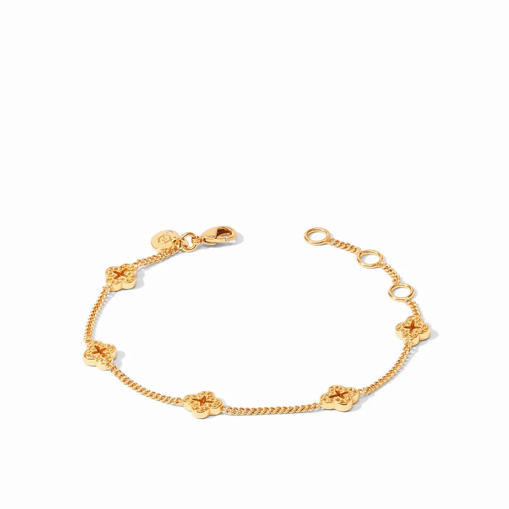 A gold bracelet with delicate chain links and decorative clover-shaped charms on a white background.