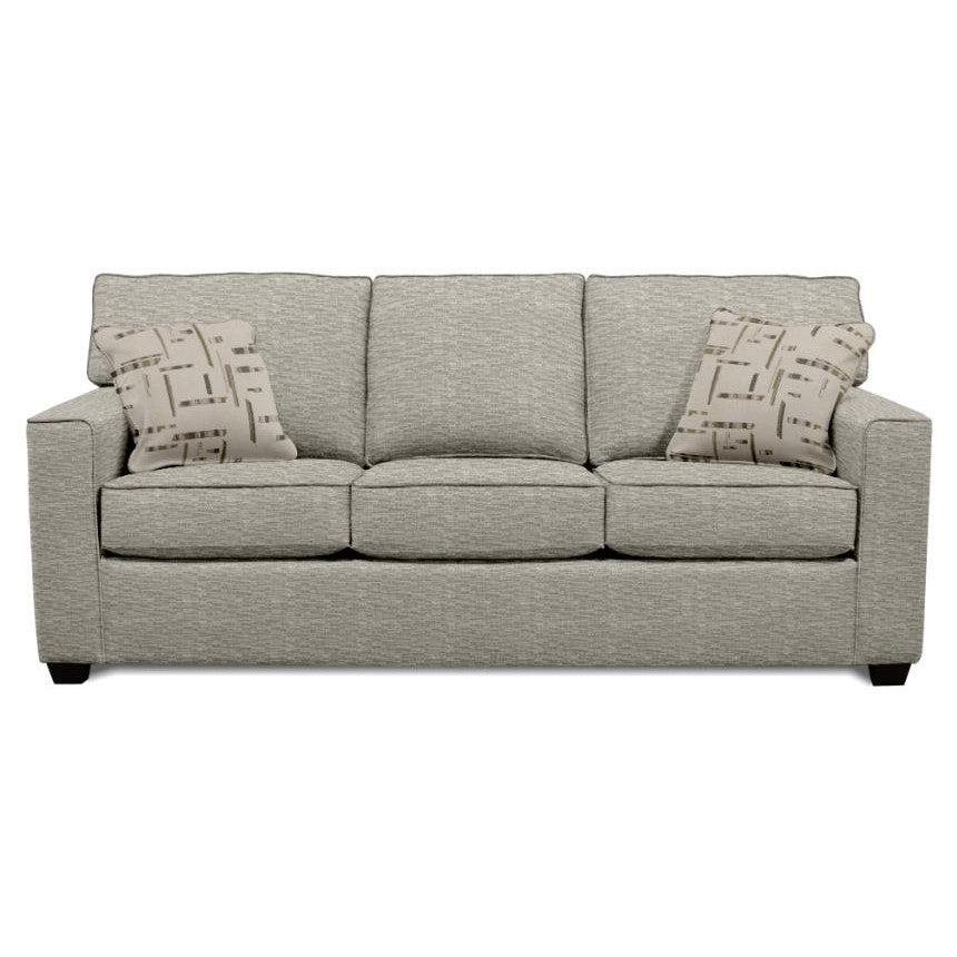 Gray sofa with two patterned pillows against a plain background.