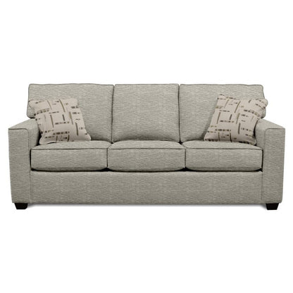 Gray sofa with two patterned pillows against a plain background.