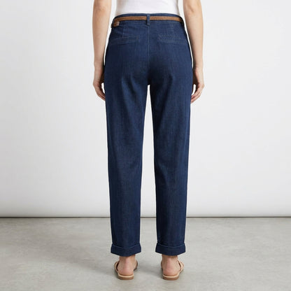 Person wearing dark blue jeans and sandals, viewed from the back.