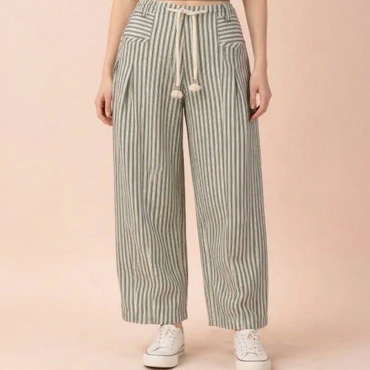 Striped wide-leg pants with drawstring, paired with white sneakers.