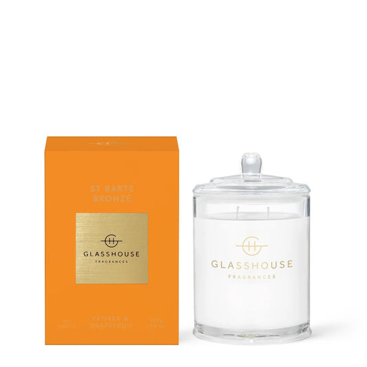 Orange box and clear lidded candle, "Glasshouse Fragrances" branding visible.