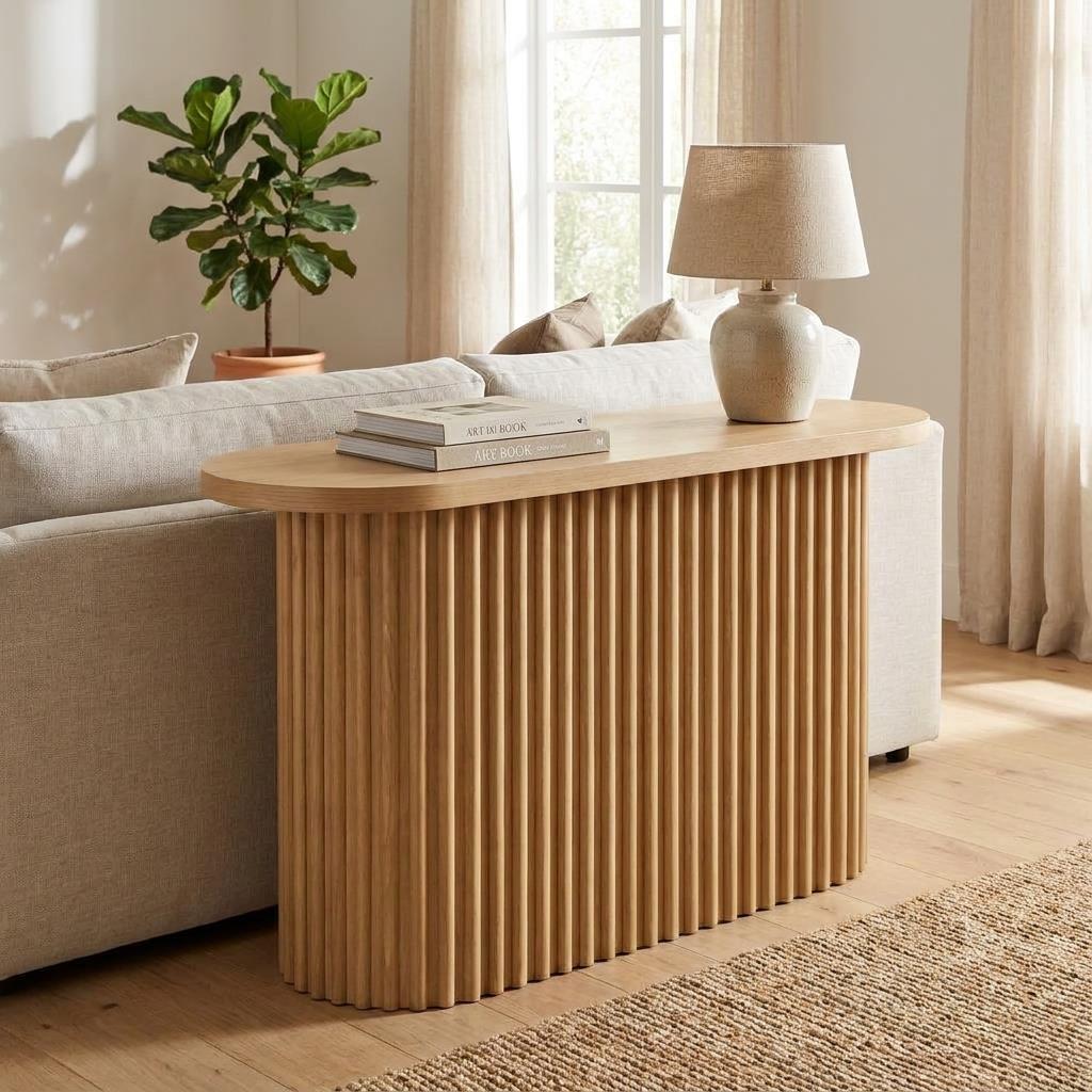 Wooden console table with vertical grooves and round edges.