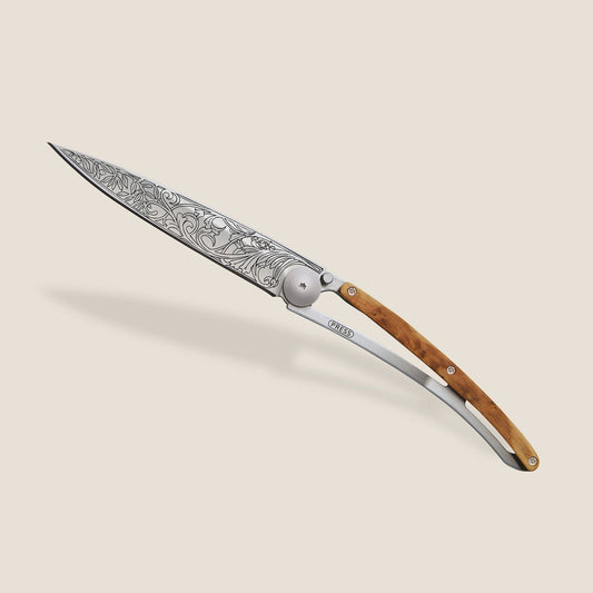 Ornate knife with intricate blade design and wooden handle.