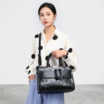 Person in polka-dot blouse holding a stylish black handbag.