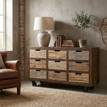 Rustic wooden dresser with nine drawers on wheels.