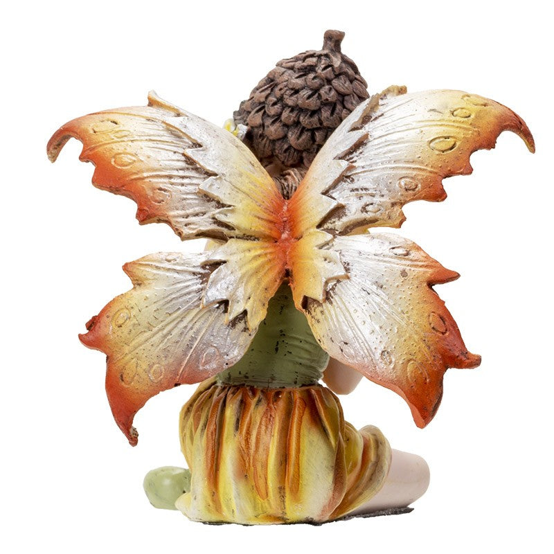 Seated fairy figurine with large orange and yellow wings.