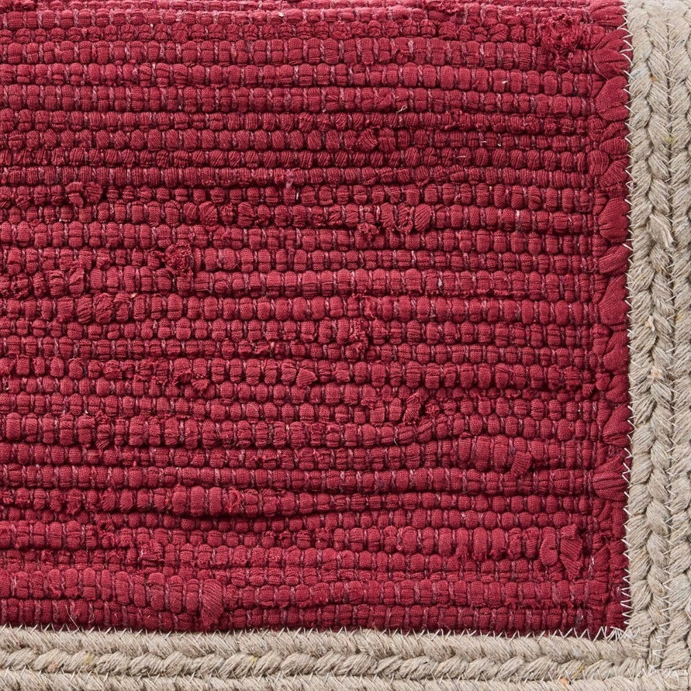 Red woven textile with beige braided border.