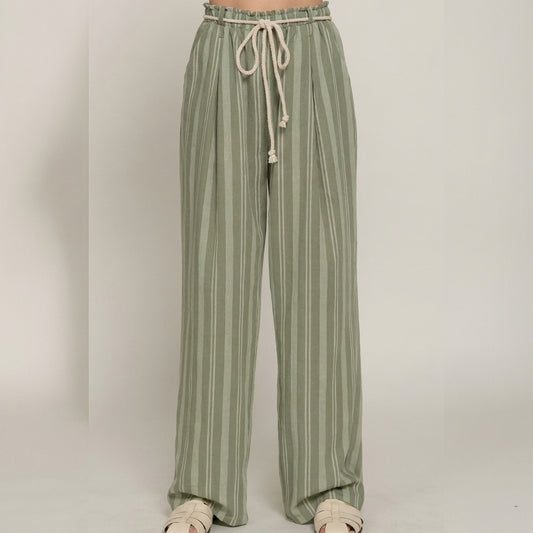 Green striped pants with a drawstring waist and white sandals.