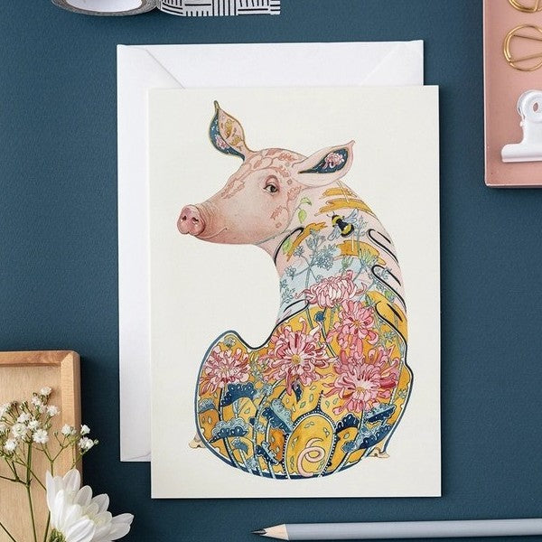 Artistic pig illustration with floral patterns.