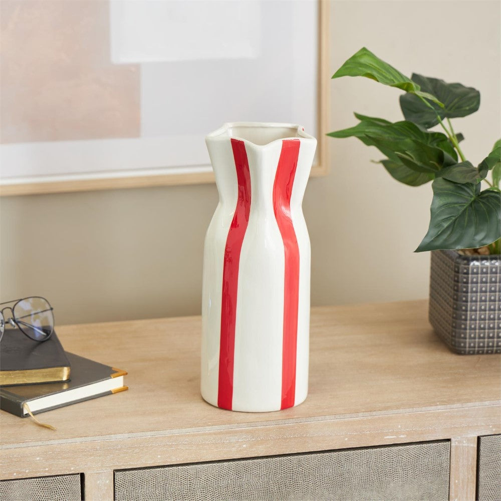 Tall ceramic vase with red stripes on a wooden table.