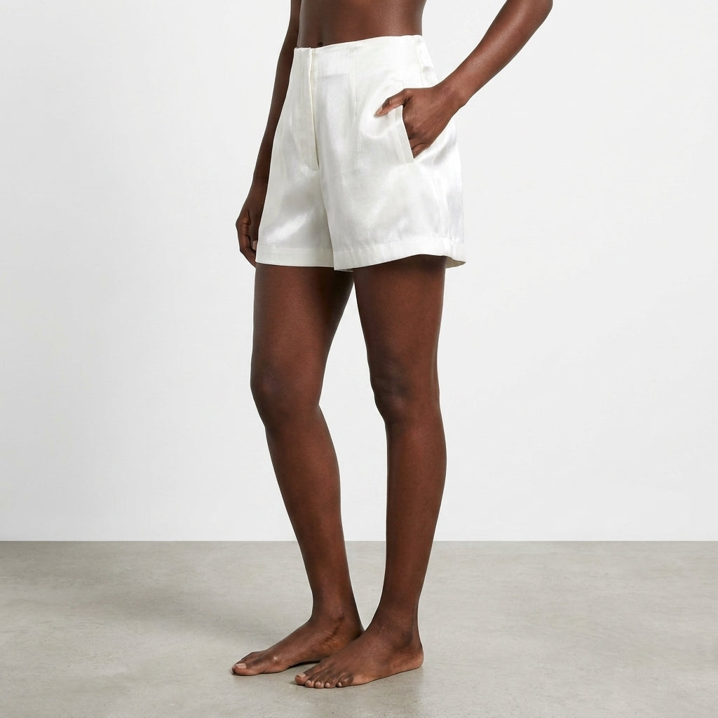 Person wearing white shorts, standing barefoot on a gray floor.