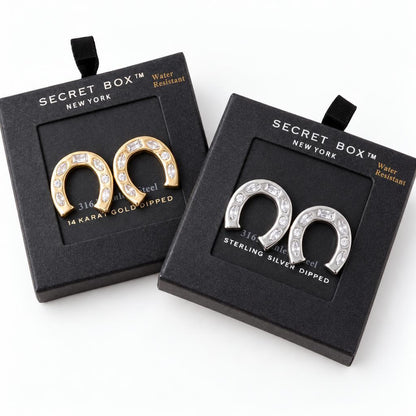 Two pairs of horseshoe-shaped earrings in gold and silver packaging.