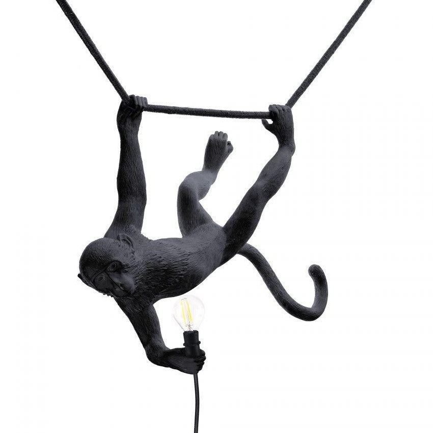 Monkey lamp sculpture holding a light bulb.