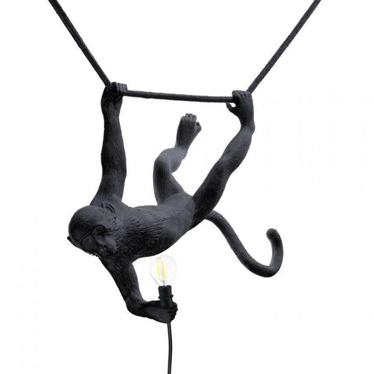 Monkey lamp sculpture holding a light bulb.