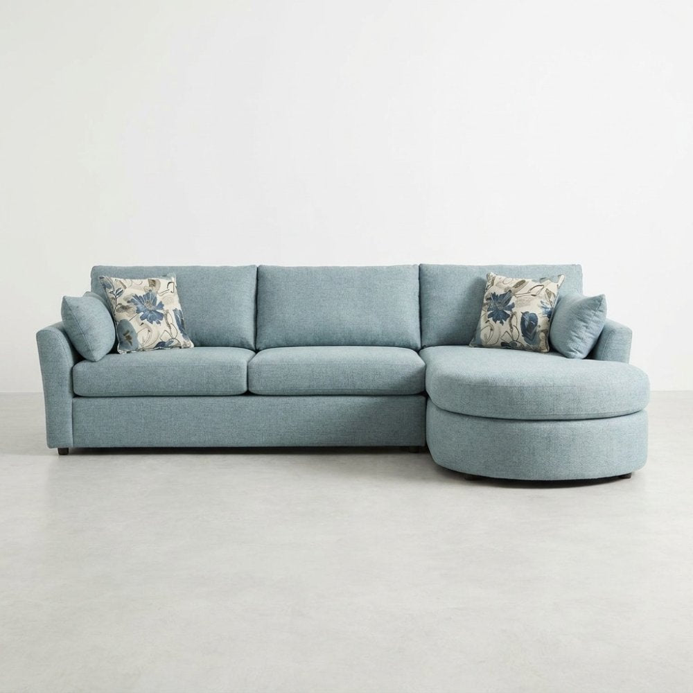 Light blue sectional sofa with floral cushions on a white background.