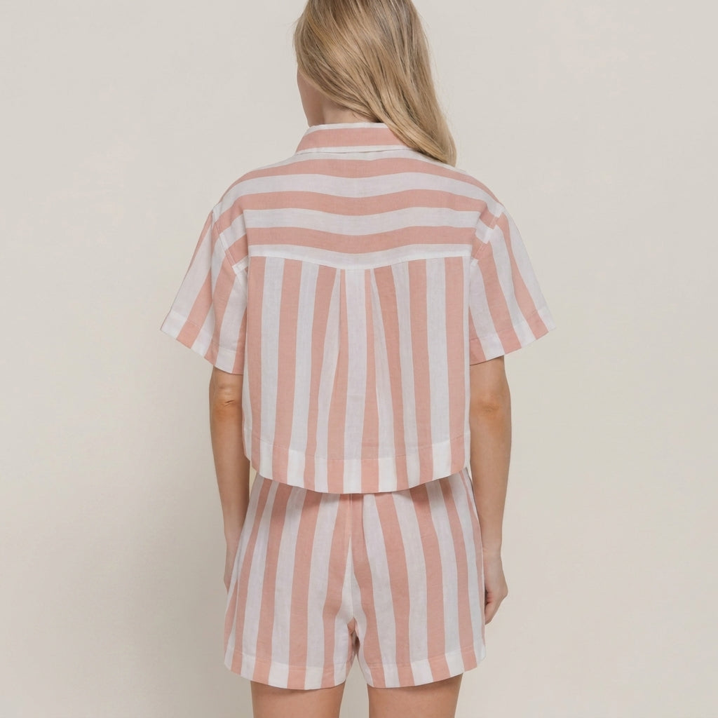 Blonde woman in pink and white striped shorts set, seen from the back.