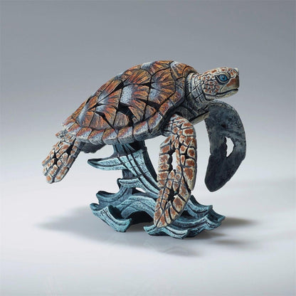 Intricate sculpture of a sea turtle on ocean waves.