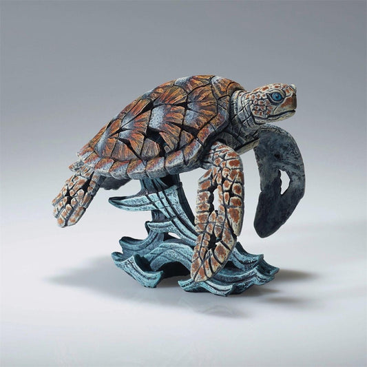 Intricate sculpture of a sea turtle on ocean waves.