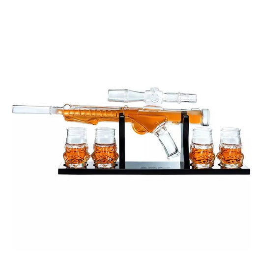 Glass gun-shaped decanter set with amber liquid and four shot glasses.