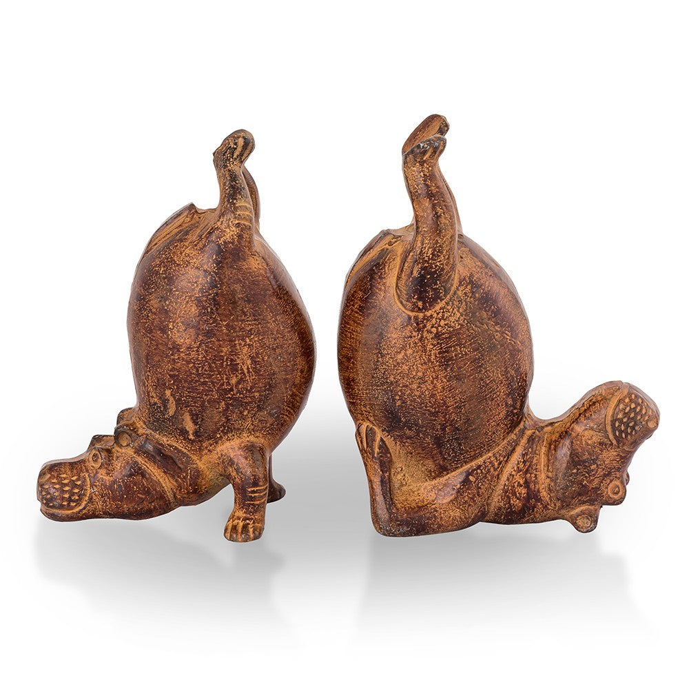 Two brown hippo figurines doing handstands.