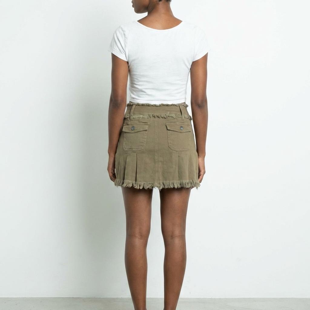 Person in a white top and khaki frayed skirt, viewed from the back.