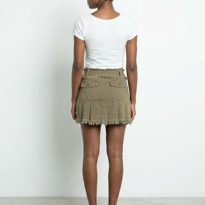 Person in a white top and khaki frayed skirt, viewed from the back.