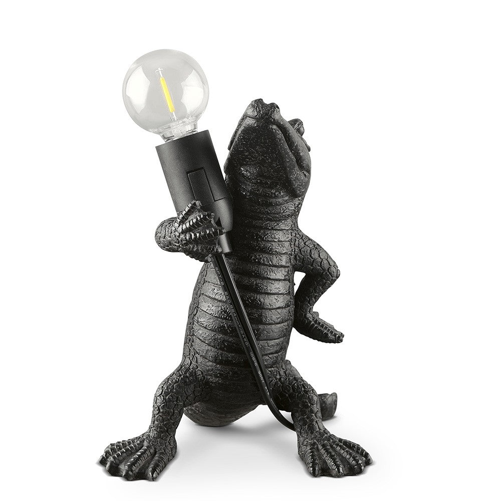 Alligator-shaped lamp holding a light bulb.