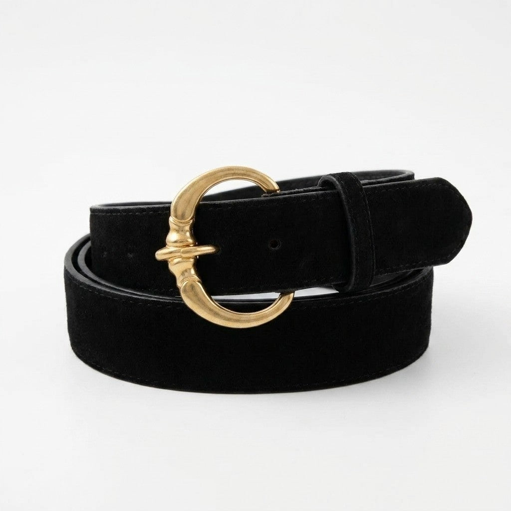 Black belt with a gold decorative buckle on display.