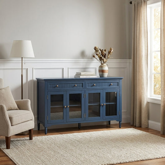 Blue sideboard, neutral armchair, vase, books, window, and lamp in a cozy, bright room.