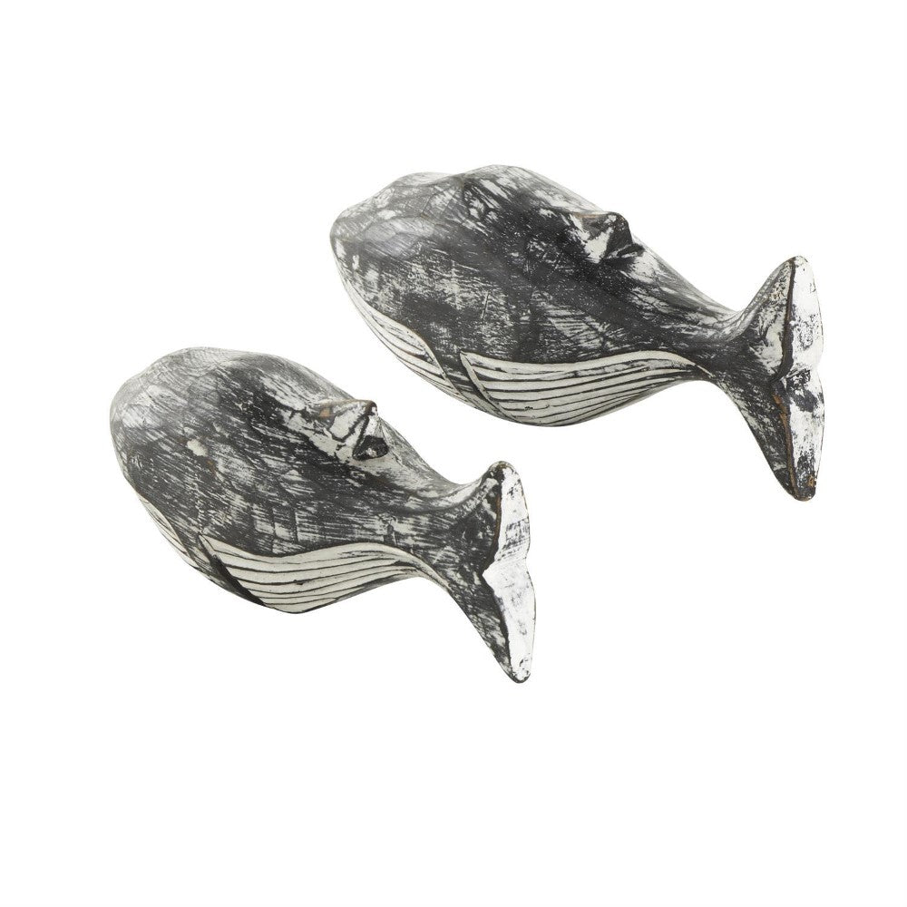 Two rustic whale sculptures with a worn, textured finish.