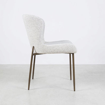 Modern chair with a textured seat and slender metal legs, side view.
