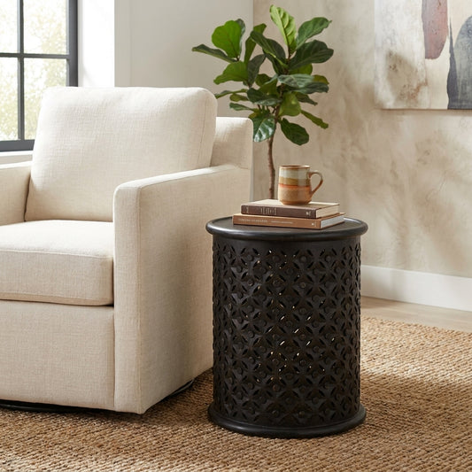 Black cylindrical container with a floral cut-out design.