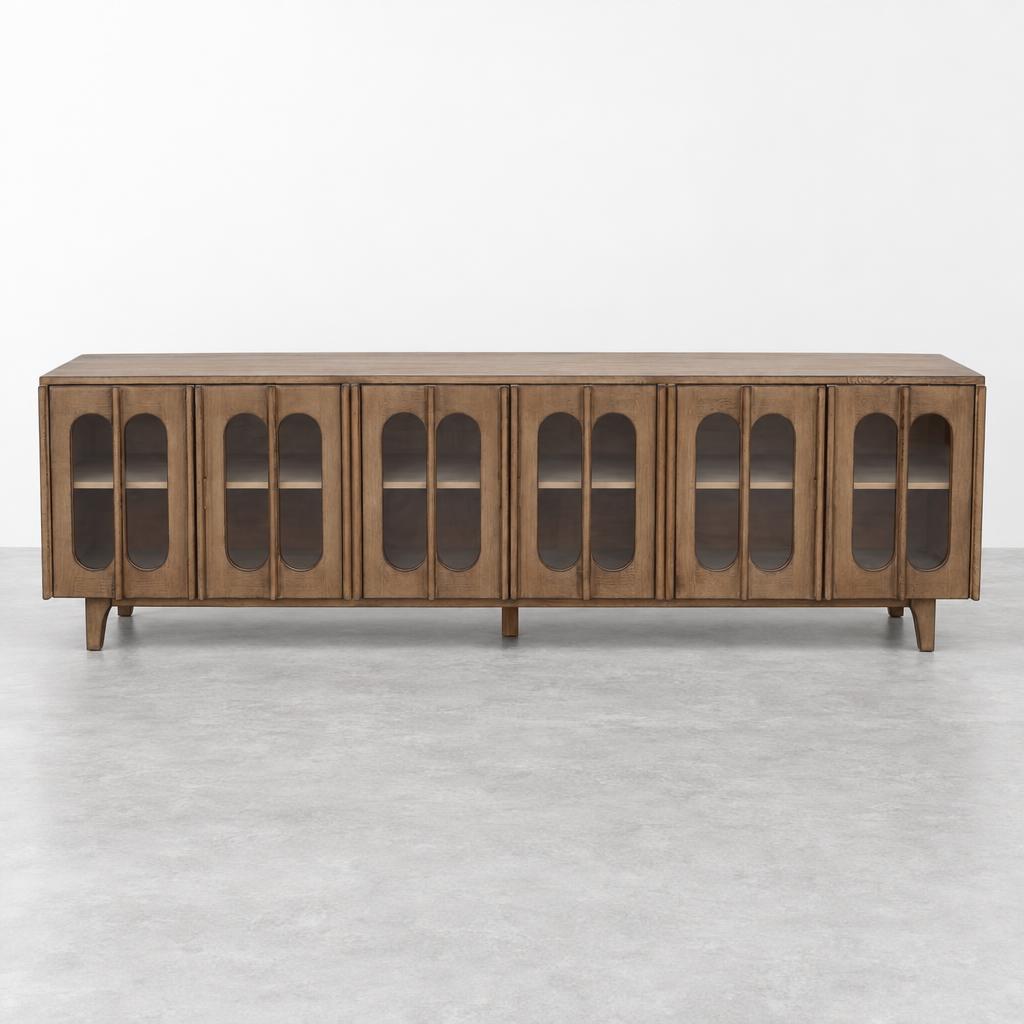 A long wooden sideboard with arched glass-panel doors stands against a plain white wall.