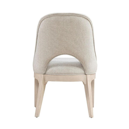 Beige upholstered chair with open back design.