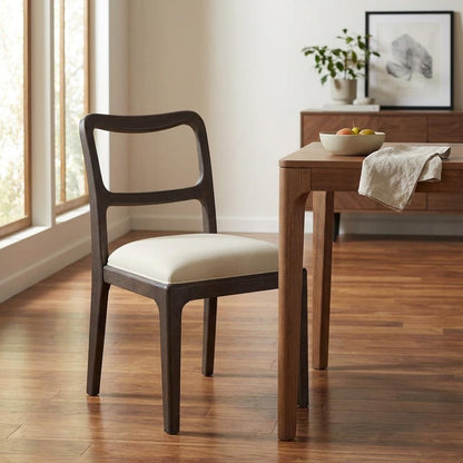 Wooden chair, table, fruit bowl on wooden floor in the sunlit room.