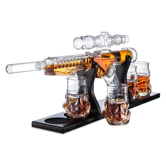 Glass gun decanter with whiskey and skull-shaped shot glasses.