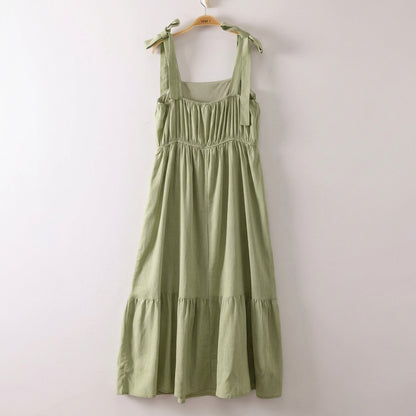 Light green dress with shoulder tie straps on a hanger.
